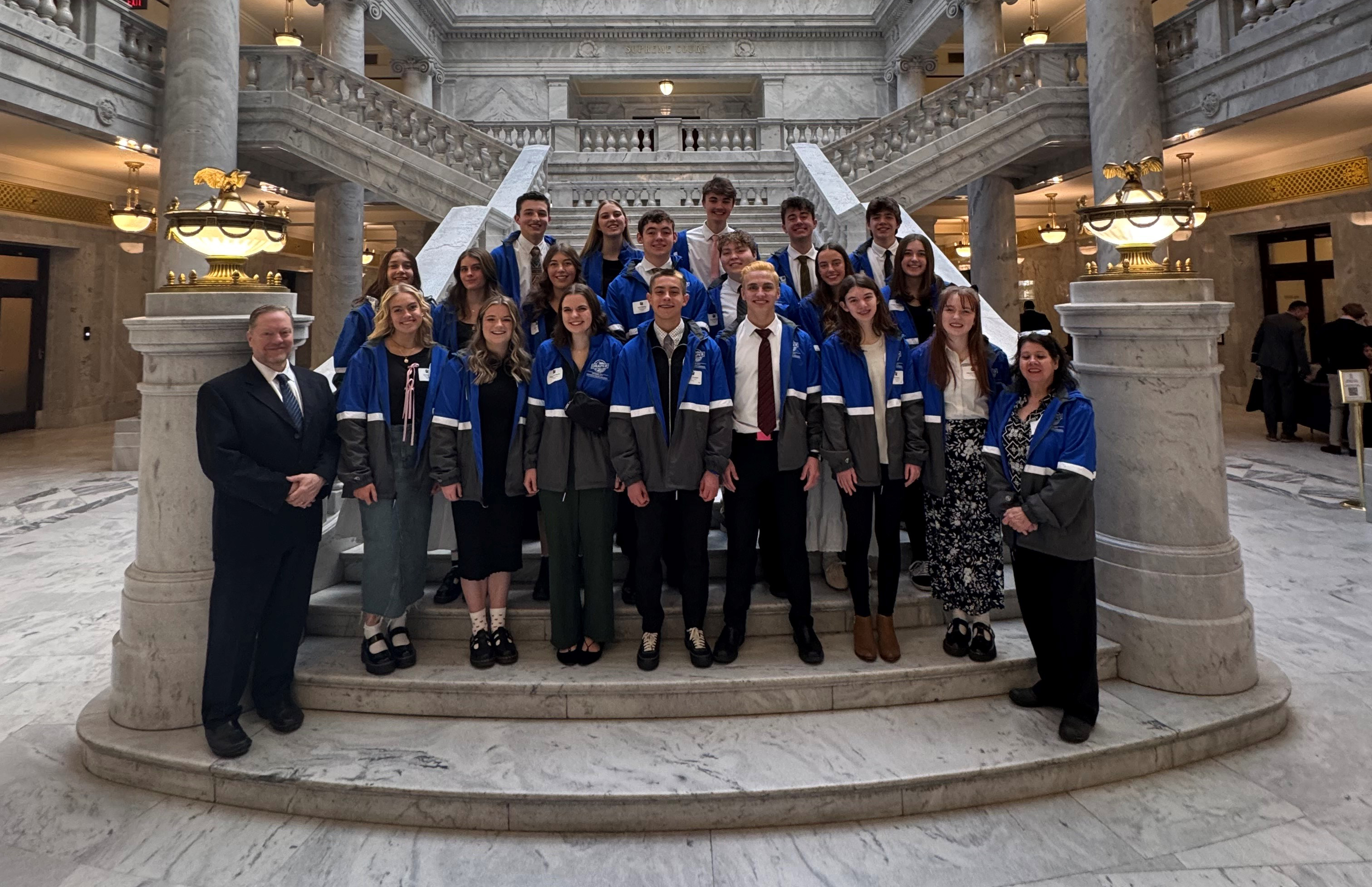 group of youth council members posed on stairs at the Utah State Capitol building with Mayor Walker and advisor Caroline Sagae